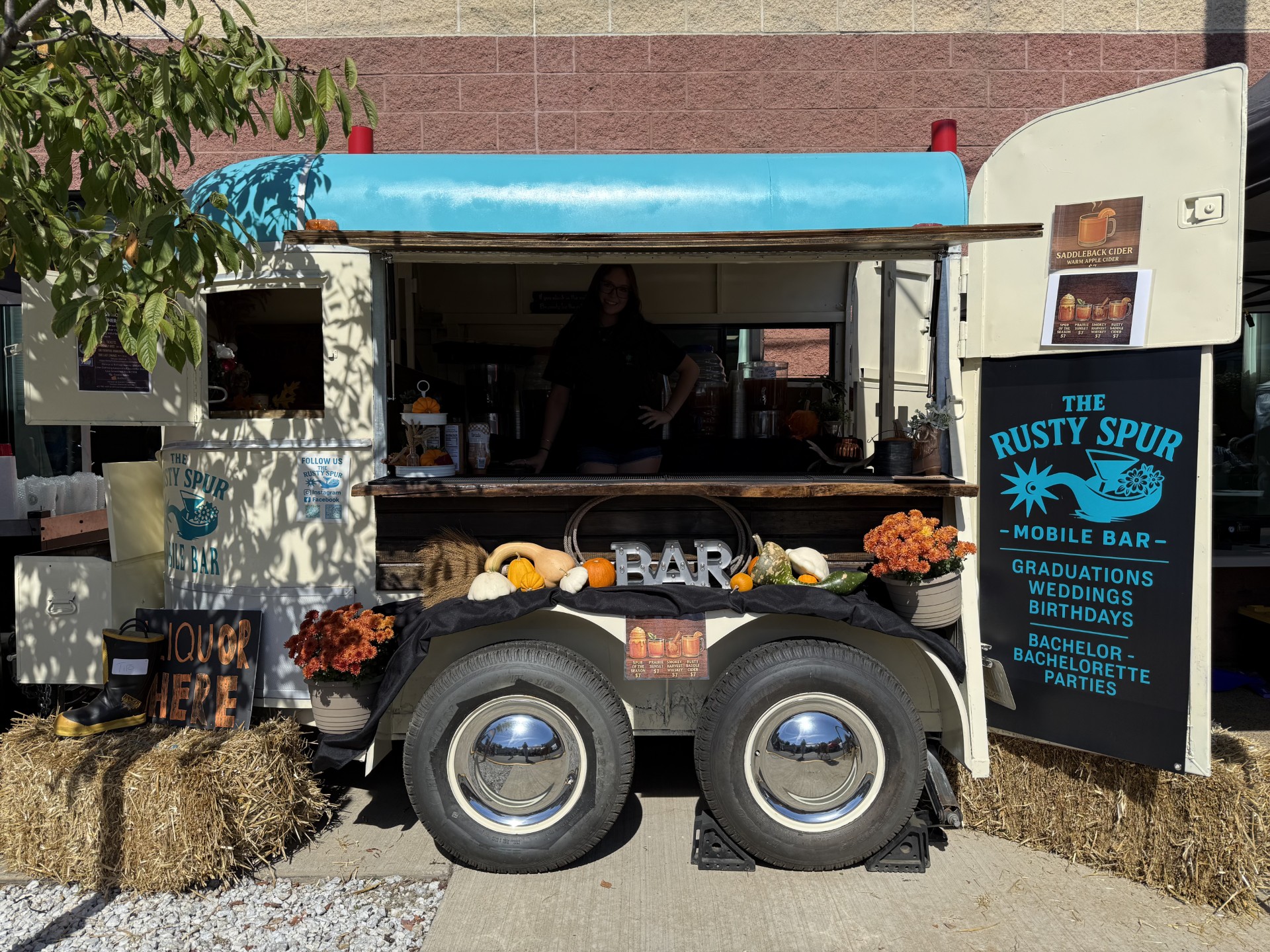 The Rusty Spur trailer dressed for fall with pumpkins, hay bales, and the chalkboard menu sign