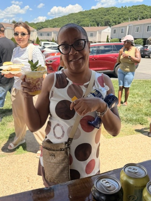 A happy guest showing off her craft cocktail at a Rusty Spur community event